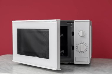 Masanın üzerinde renk arkaplanı açık olan modern mikrodalga fırın