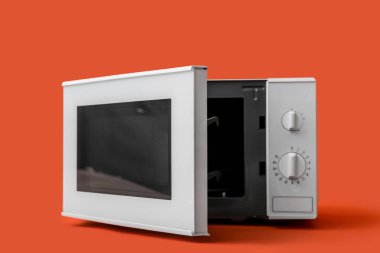 Renkli arka planda açık kapısı olan modern mikrodalga fırın