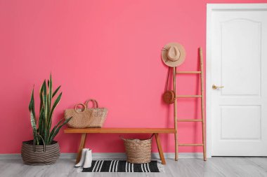 Ahşap bankları, hasır çantaları ve merdivenleri olan şık bir salon.