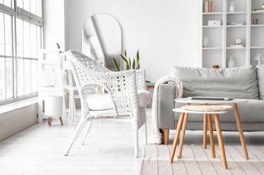 Table with modern laptop near sofa in living room interior