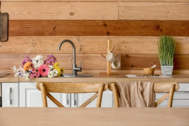 Modern kitchen with bouquet of flowers in sink