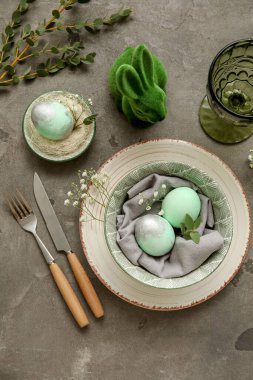 Paskalya kutlaması için şık masa dekorları. Gri arka planda çigila çiçekleri.