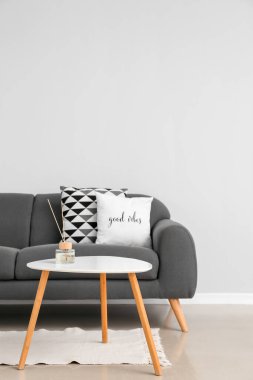 Modern kanepe ve ışık duvarının yanındaki masa.