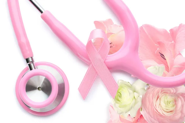 Stethoscope, pink ribbon and flowers on white background, closeup. Breast cancer awareness