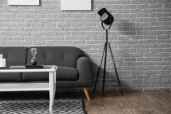 Table Hourglass Sofa Floor Lamp Grey Brick Wall — стоковое фото