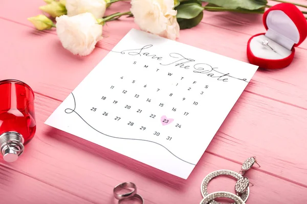 カラー木製テーブルの上にマークされた日付と女性のアクセサリーと結婚式のカレンダー — ストック写真