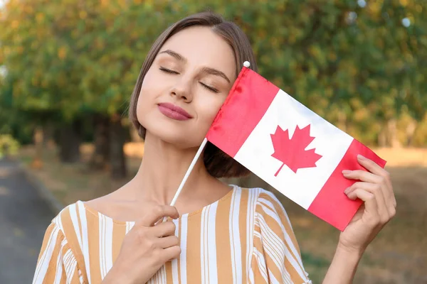 美丽的年轻女子在户外悬挂加拿大国旗 — 图库照片