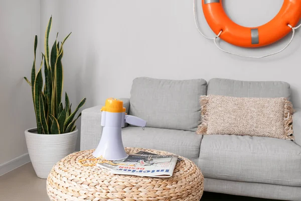 Düdüklü megafon ve oturma odasında puf dergileri.