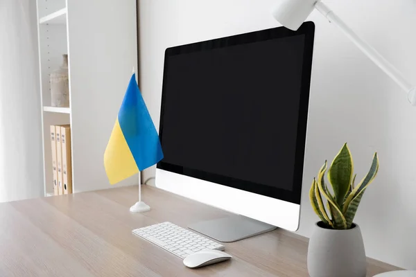 现代化工作场所 配有计算机 乌克兰国旗 家居用品和灯具 靠近轻墙 — 图库照片