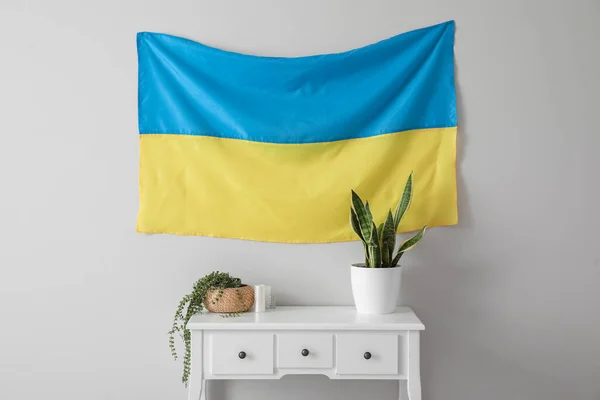 Tafel Met Kamerplanten Kaarsen Oekraïense Vlag Hangend Aan Lichtmuur — Stockfoto