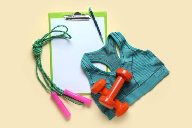 Kalem, spor bluz, dambıl ve bej arka planda ip atlama ile pano