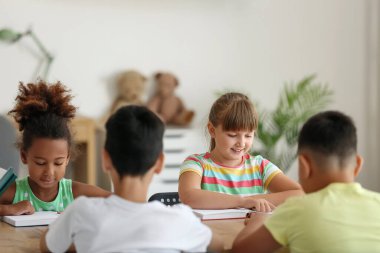 Sınıfta kitap okuyan küçük kızlar.