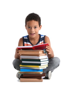 Little African-American boy reading book on white background