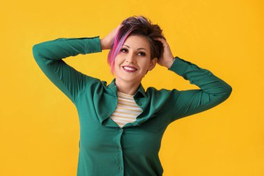 Sarı arka planda kısa boyalı saçlı güzel bir kadın.