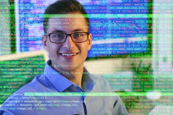 Double exposure of handsome male programmer in office and computer code