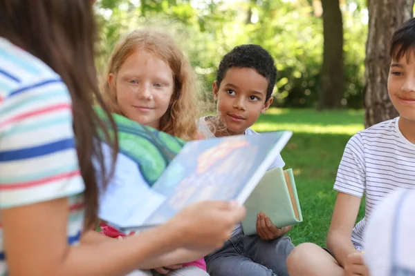 Professora Leitura Livro Para Seus Alunos Parque — Fotografia de Stock