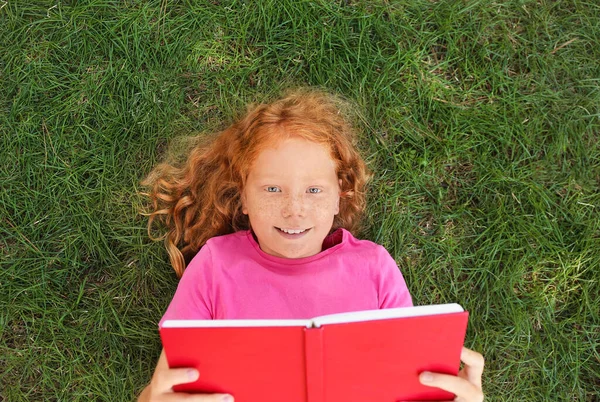 Little Redhead Girl Reading Book Green Grass — Stockfoto