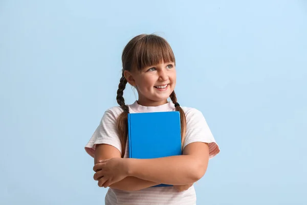 Kleines Mädchen Mit Zöpfen Hält Buch Auf Blauem Hintergrund — Stockfoto