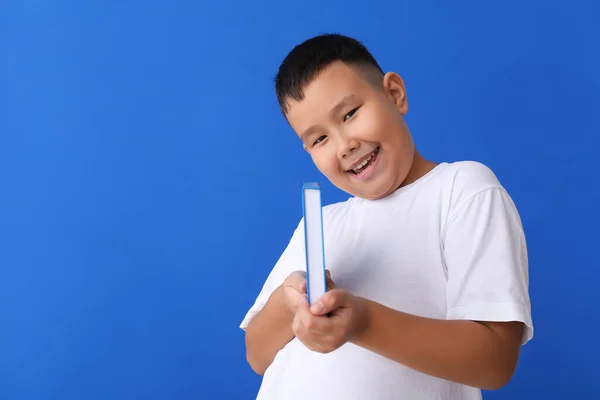 Mavi Arka Plan Kitabı Olan Küçük Asyalı Çocuk — Stok fotoğraf