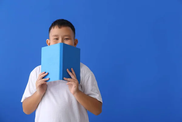 Kleiner Asiatischer Junge Mit Buch Auf Blauem Hintergrund — Stockfoto
