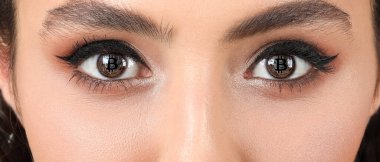 Gözlerinde Bitcoin 'in yansıması olan güzel genç bir kadın, yakın plan.