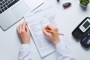 Beyaz arka planda laboratuvar test formunda yazan kadın doktor.