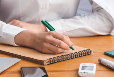 Masada deftere yazan kadın doktor, yakın plan.