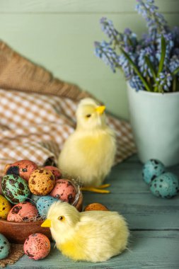 Tatlı tavuklar, Paskalya yumurtaları ve çiçekler masada.