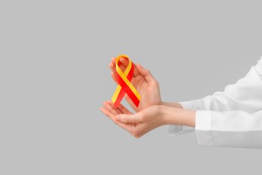 Gri arka planda farkındalık kurdelesi olan kadın doktor. Hepatit konsepti