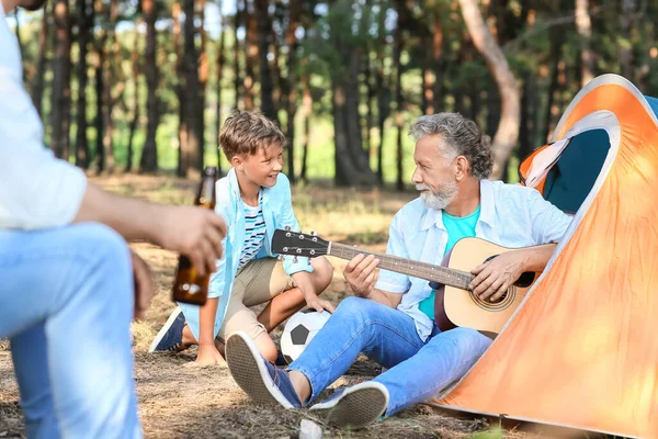 Hombre Mayor Tocando Guitarra Para Familia Bosque —  Fotos de Stock