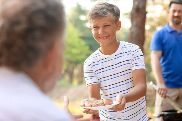 Little Boy Giving Plate Grilled Meat His Grandfather Barbecue Party — Stock Photo, Image