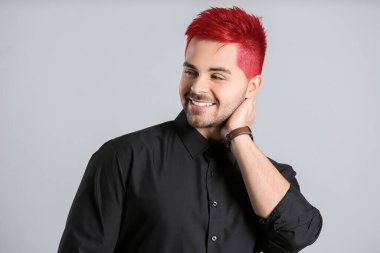 Tarz sahibi genç adam, açık arkaplanda sıradışı kızıl saçlı.