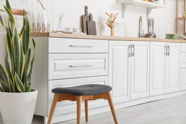 Beyaz tezgah ve çatal bıçaklarla aydınlık mutfağın içinde.