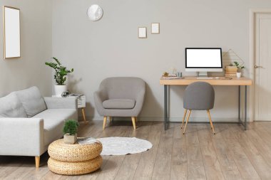 Çalışma yeri, kanepesi ve koltuğu olan modern bir oda.