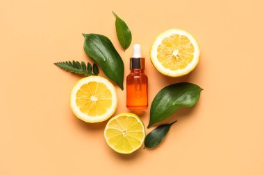 Limonlu ve bej arkaplanda bitki yapraklı bir şişe doğal serum.