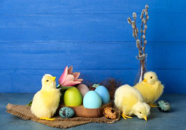Cute chickens, Easter eggs, flower and pussy willow branches on table