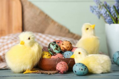Tatlı tavuklar, Paskalya yumurtaları ve çiçekler masada.