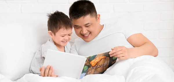 Asian Man His Little Son Reading Book Bed — Stockfoto