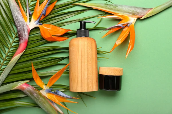 Yeşil arka planda kozmetik ürünleri ve strelitzia çiçekleri