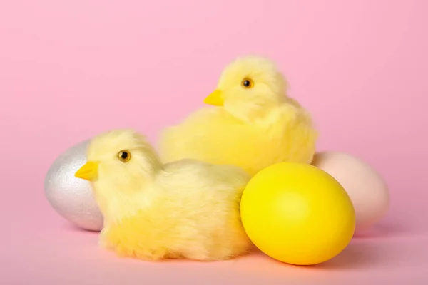 かわいい黄色の鶏とピンクの背景にイースターエッグ — ストック写真