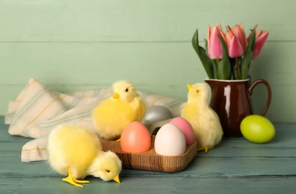 Cute chickens, tulips and Easter eggs on table