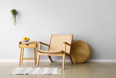 Modern koltuk, masa ve puf ışık duvarı yanında.