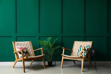 Yeşil duvarın yanında şık koltuklar ve bitkiler