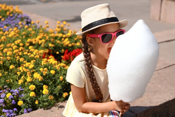 Cute Little Girl Eating Cotton Candy Outdoors — стоковое фото