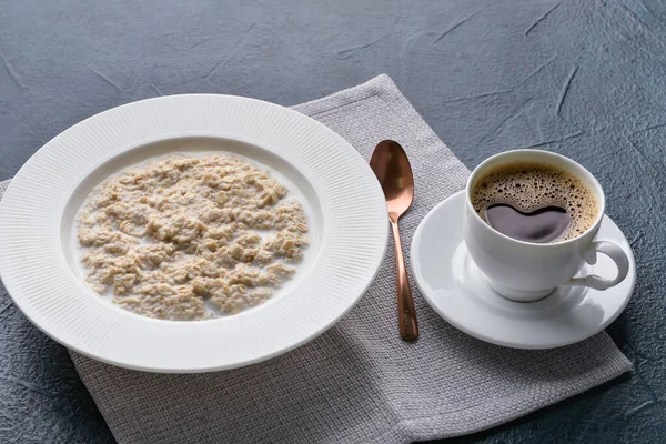 Bir tabak lezzetli yulaf ezmesi ve siyah arka planda kahve.