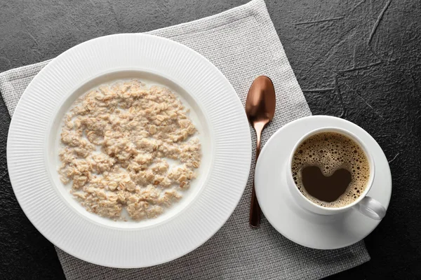 Bir tabak lezzetli yulaf ezmesi ve siyah arka planda kahve.