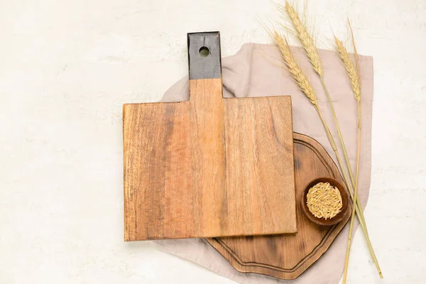 Tahta kesme tahtaları ve arka planda buğday taneleri.