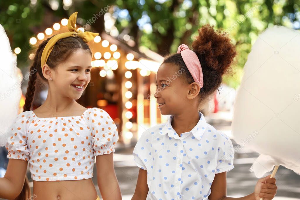 Cute little girls with cotton candy outdoors
