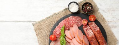 Beyaz ahşap zemin üzerinde farklı türde sosis ve metin için yeri olan tahta tabaklar.