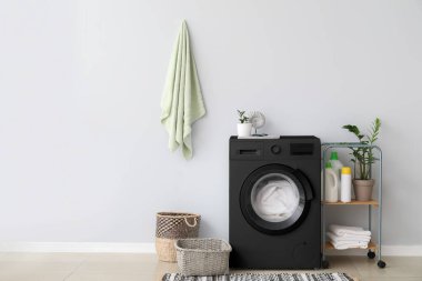 Modern siyah çamaşır makinesiyle aydınlık banyonun içi